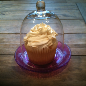 White fronsted cupcake in glass case